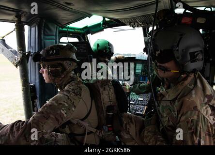 Un Airman dal 320th Special Tactics Squadron (a sinistra), Capt. Ben Bourgeois (al centro), 459th Airlift Squadron pilota, e Master Sgt. Todd Chandler (a destra), 459 COME ingegnere di volo, si prepara per un veloce esercizio di corda a bordo di un elicottero Iroquois UH-1N durante un evento di Rescue Rodeo alla base aerea di Yokota, Giappone, 12 maggio 2021. Rescue Rodeo è stato un evento della durata di una settimana che ha testato il 320th STS su operazioni di ricerca e salvataggio di combattimento in una varietà di esercizi di addestramento. Foto Stock