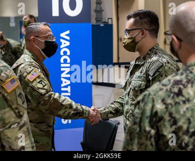 U.S. Navy Seaman Jeremy-John Utchell, a destra, un ricovero assegnato al Naval Medical Center Portsmouth, Virginia, riceve una moneta da U.S. Army Briga. Gen. Ronald Cuples, a sinistra, assistente generale della Guardia Nazionale del Massachusetts, per essere stato il Vaccinatore della settimana dal 26 aprile al 2 maggio e per aver vaccinato circa 465 membri della comunità locale, presso il Centro comunitario di vaccinazione presso il Centro Congressi Hynes presso il Centro Congressi Hynes di Boston, Maggio 12, 2021. Il comando del Nord degli Stati Uniti, attraverso il Nord dell'esercito degli Stati Uniti, rimane impegnato a fornire un Departme continuo e flessibile Foto Stock