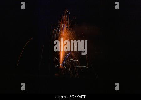 piccolo fuochi d'artificio sparkler rosso a terra nel buio della notte Foto Stock