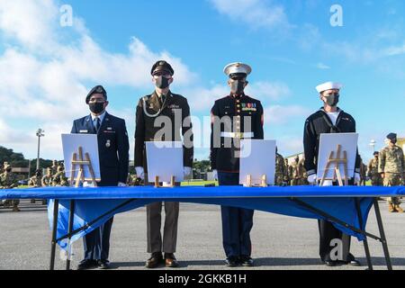 I membri del servizio USA si esibiscono con una guardia di colore interservizio durante una cerimonia per la settimana della polizia alla stazione di Torii, Okinawa, Giappone, 14 maggio 2021. Alla cerimonia hanno partecipato la polizia militare del Provost Marshal's Office del corpo Marino degli Stati Uniti, il 18esimo Squadron delle forze di sicurezza dell'aeronautica degli Stati Uniti, il comandante della Marina degli Stati Uniti Fleet Activities Okinawa e il 247esimo distaccamento della polizia militare dell'esercito degli Stati Uniti, che è stato uno dei numerosi eventi che commemoravano la settimana della polizia, Che è stato effettuato dal 10 al 14 maggio. Foto Stock