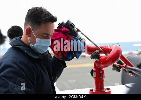 210515-N-NM271-1072 OCEANO PACIFICO (15 maggio 2021) – Aviation Boatswain’s Mate (Handling) Airman Dominic Wyatt, di Charleston, Ind., esegue la manutenzione di un veicolo antincendio aereo sul ponte di volo a bordo della nave d’assalto anfibio USS Tripoli (LHA 7), maggio 15. Tripoli sta conducendo operazioni di routine nella terza flotta statunitense. Foto Stock