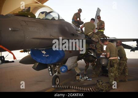 157th Expeditionary Fighter Generation Squadron i capi di equipaggio e gli artigiani elettrici e ambientali eseguono la manutenzione su un F-16 Fighting Falcon alla base aerea Prince Sultan, Regno dell'Arabia Saudita, 16 maggio 2021. I velieri della Guardia Nazionale dell'aria del South Carolina vengono dispiegati in PSAB per proiettare il potere di combattimento e aiutare a rafforzare le capacità difensive contro le potenziali minacce nella regione. Foto Stock