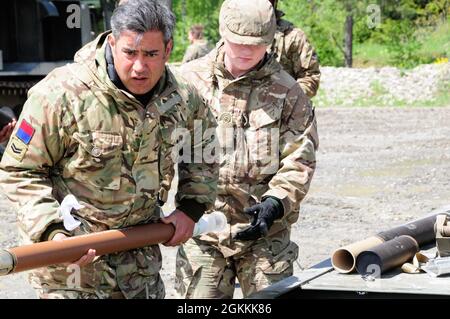 Soldati britannici assegnati a 132 Battery, 26th Regiment Royal Artillery Reload Rocket Rocket Reduced Range Practice nel loro M270 Multiple Launch Rocket Systems tra la missione di fuoco il 18 maggio 2021 a Grafenwoehr Training Area, Germania come parte della multinazionale artiglieria Live Fire Exercise Dynamic Front 21. DF21 è un 7° Esercito-addestramento guidato da comando, US Army Europe e Africa-diretto esercizio progettato per aumentare la prontezza, la letalità e l'interoperabilità esercitando la capacità di nazioni alleate e partner di integrare gli incendi congiunti in un ambiente multinazionale sia a livello operativo che tattico Foto Stock