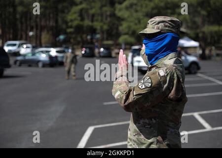 Arizona Army National Guard Sgt. James Garcia, 1404 Transportation Company dirige i pazienti vaccinati come parte del controllo del traffico in una clinica di vaccinazione pop-up a Munds Park, Ariz. 19 maggio 2021. Le vaccinazioni fanno parte dello sforzo della Guardia Nazionale Arizona di aumentare la capacità e la capacità di fornire le vaccinazioni alle aree rurali di tutta l’Arizona. Foto Stock