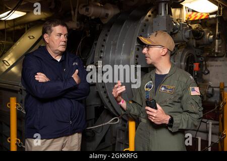 Il Dr. Raymond o'Toole Jr., direttore, test operativi e valutazione, a sinistra, parla con il Capitano Paul Lanzilotta, USS Gerald R. Ford's (CVN 78) comandante ufficiale, in uno dei locali avanzati di macchine di arresto Ford durante una visita della nave, 19 maggio 2021. Il Dr. O'Toole ha visitato Ford per condurre una valutazione visiva della disponibilità della nave per le prove Full Ship Shock Trials (FSST). Ford è in porto Naval Station Norfolk facendo i preparativi finali per FSST. Foto Stock