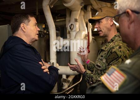 Il Dr. Raymond o'Toole Jr., direttore, test operativi e valutazione, a sinistra, parla con il Capt. Brian Metcalf, Program Manager PMS 378, centro, in una delle sale del generatore di motori USS Gerald R. Ford (CVN 78) per il sistema di lancio di aeromobili elettromagnetici durante una visita alla nave, 19 maggio 2021. Il Dr. O'Toole ha visitato Ford per condurre una valutazione visiva della disponibilità della nave per le prove Full Ship Shock Trials (FSST). Ford è in porto Naval Station Norfolk facendo i preparativi finali per FSST. Foto Stock