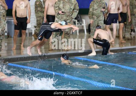 Un partecipante che rappresenta il 1° Battaglione, 28° Reggimento fanteria, si tuffa in un compagno di squadra durante la gara di nuoto relay come parte della Marne Week 20 maggio 2021, a Fort Stewart, Georgia. Durante la Marne Week, i soldati Dogface di tutta la Divisione hanno partecipato a atletica e sport per costruire coesione di squadra e spirito competitivo, tra cui softball, basket, pallavolo, calcio, calcio balilla, rimorchiatore di guerra, nuoto, combattivi, crossfit, E la Marne Mudder. Foto Stock