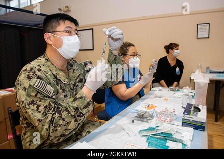 YOKOSUKA, Giappone (20 maggio 2021) – Ospedale Corpsman II Classe Yan Wang, assegnato all'Ospedale Navale degli Stati Uniti Yokosuka, e Laurei Fernandes, RN, volontario della Croce Rossa americana, preparano siringhe con dosi del vaccino Pfizer COVID-19 durante una distribuzione del vaccino presso il Nest Hawk del Comandante, Fleet Activities Yokosuka (CFAY). Con l'autorizzazione del Dipartimento della Difesa, la CFAY ha iniziato a somministrare vaccini a bambini da 12 a 17 anni con contratto di status of Forces Agreement sponsorizzato dalla Marina durante i due giorni di distribuzione. Da oltre 75 anni, CFAY ha fornito, mantenuto e gestito le strutture di base e. Foto Stock