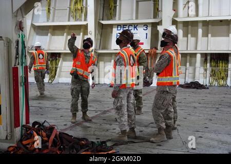 Marines con la forza di lavoro militare militare militare militare militare militare militare USA - Risposta di crisi - comando centrale, carico di navi testimone in varie fasi come il capitano dell'esercito Mathew Mollet, responsabile del team di gestione del terminale, con Lancaster della Riserva dell'esercito, Pa., Based 1185th Deployment and Distribution Support Battaglione, Mostra le capacità della nave Alliance Norfolk durante le operazioni nel porto di Shuaiba, Kuwait. Giugno 26, 2021. Foto Stock