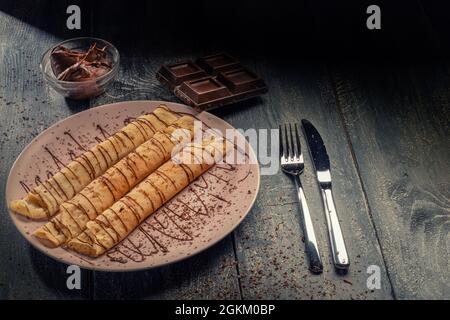 Deliziose frittelle con cioccolato su sfondo di legno scuro Foto Stock