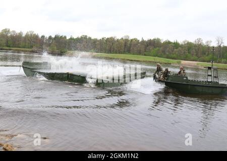 I soldati della riserva dell'esercito dalla 652a compagnia di ingegneria si preparano ad agganciare una parte del ponte a nastro migliorato per attaccarlo ad altre parti per creare un ponte galleggiante a Fort McCoy, Wis., 21 maggio 2021. L'addestramento permette a questo Hammond, Wis., basato l'unità di costruzione del ponte per diventare più competente nella costruzione dei punti di attraversamento per i convogli militari di veicoli gommati o cingolati. Foto Stock