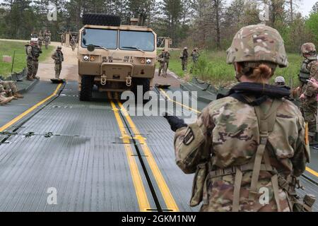 Riserva dell'esercito PFC. Iryna Sachek, membro dell'equipaggio di un ponte con la Hammond, Wis., 652nd Engineer Company, guida un camion con sistema di carico pallettizzato su un ponte galleggiante come parte dell'addestramento a Fort McCoy, Wis., 21 maggio 2021. Ai soldati fu affidato il compito di costruire un ponte galleggiante e spostare i veicoli militari da una parte del Big Lake Sandy all'altra. Foto Stock