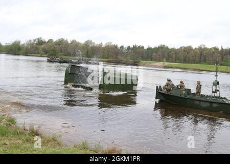 I soldati della riserva dell'esercito dalla 652a compagnia di ingegneria si preparano ad agganciare una parte del ponte a nastro migliorato per attaccarlo ad altre parti per creare un ponte galleggiante a Fort McCoy, Wis., 21 maggio 2021. L'addestramento permette a questo Hammond, Wis., basato l'unità di costruzione del ponte per diventare più competente nella costruzione dei punti di attraversamento per i convogli militari di veicoli gommati o cingolati. Foto Stock