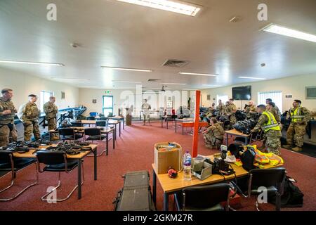 Gli airmen dei 422d e 423a Squadroni delle forze di sicurezza, ascoltano un briefing prima di un esercizio di forza-forza alla RAF Molesworth, Inghilterra, 21 maggio 2021. I difensori della 422d e della 423a SFS si sono riuniti per affinare le loro riprese, muoversi, comunicare tattiche mentre hanno risposto a diversi scenari volti ad affinare le loro abilità in situazioni di forza letale. Foto Stock