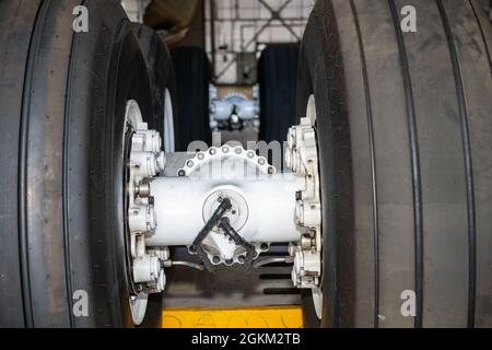 Una vista ravvicinata del complessivo ruota dentata di atterraggio di una C-5M Super Galaxy in manutenzione il 21 maggio 2021 presso la base dell'aeronautica di Travis, California. Il C-5 è dotato di un carrello di atterraggio retrattile del tipo a triciclo. Sono presenti quattro unità di atterraggio principali montate in coppie tandem. Ciascuna delle quattro unità principali è dotata di un carrello a sei ruote con due ruote in avanti e quattro ruote posteriori dell'ammortizzatore. Le unità principali vengono ruotate di 90 gradi per la ritrazione verso l'interno mediante un sistema di ingranaggi a comando idraulico. Il carrello è dotato di ammortizzatori Bendix oleopneumatici a doppia camera, ruote Goodrich, carbonio d Foto Stock