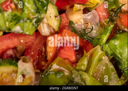 Insalata di verdure di pomodori a fette, cetrioli, peperoni dolci, ravanelli ed erbe, primo piano, messa a fuoco selettiva Foto Stock