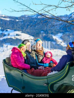 Godetevi la vostra vacanza invernale con un giro in slitta trainata da cavalli nella foresta di Bregenz innevata Foto Stock