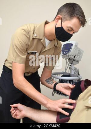 JACKSONVILLE, Fla. (21 maggio 2021) - Ospedale Corpsman III Classe Andrew Hill controlla la pressione sanguigna di un paziente presso la clinica sanitaria Behavioral di Jacksonville. Hill, nativo di King William, Virginia, afferma: “i Corpsmen aiutano a semplificare il processo prendendo appuntamenti e controllando i pazienti per i fornitori”. I Corpsmen svolgono un ruolo chiave nella preparazione medica e dentale di marinai e marines. Il corpo ospedaliero della Marina, il più grande e più decorato della Marina, celebra 123 anni di servizio il 17 giugno. Foto Stock