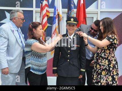 Il cadetto Tiffany Paruolo, assegnato al terzo Battaglione della Guardia Nazionale dell'Esercito di New York, 142o Regiment Aviazione, ha il suo rango ufficiale fissato sulla sua uniforme dai genitori, Laura Paruolo e Anthony J. Paruolo, veterano della Guerra del Vietnam, Sua sorella Alyson Smith e il fratello Anthony D. Paruolo alla cerimonia primaverile della ROTC dell'Università di Hofstra, presso il Museo dell'armatura americana, Old Bethpage, N.Y., sabato 22 maggio 2021. Foto Stock