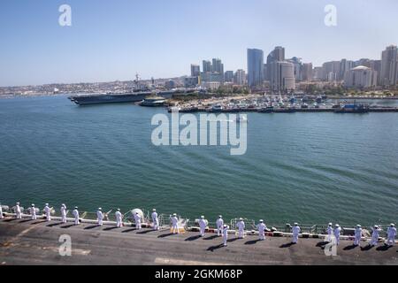 210523-N-TF178-1100 SAN DIEGO (23 maggio 2021) marinai uomo le rotaie a bordo della nave d'assalto anfibio USS Makin Island (LHD 8) mentre ritorna il suo homeport della base navale di San Diego. Makin Island, nave principale del Makin Island Amphibious Ready Group, è tornato alla base navale di San Diego dopo un dispiegamento alle flotte statunitensi 3, 5, 6 e 7 dove hanno servito come forza di risposta alla crisi per i comandanti combattenti in Africa, Centrale e Indo-Pacifico. Foto Stock