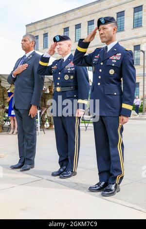 Da sinistra a destra: U.S. Army Gen. (Ret.) Vincent Brooks, U.S. Army Major. Gen. Douglas A. Sims, il Fort Riley e la prima divisione di fanteria che comandano il generale, e U.S. Army Briga. Il generale Andrew Gainey, il vice comandante generale di manovra, prima divisione di fanteria, paga i loro rispetti durante l'inno nazionale in una cerimonia al Fort Riley e la prima sede centrale della divisione di fanteria a Fort Riley, Kansas, 24 maggio 2021. La cerimonia si è svolta per promuovere Gainey dal rango di colonnello al brigadiere generale. Foto Stock