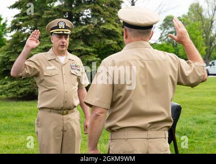 GRANDI LAGHI, il. (25 maggio 2021) il Capitano Ken Williams, dirigente, Naval Station Great Lakes, di Sandusky, Ohio, presta giuramento al Capitano Patrick Sutton, comandante, Training Support Center Great Lakes, durante una cerimonia di promozione su Ross Field. Williams si arruolò nella Marina 1987 e commissionò come capo-garante nel 1999. Foto Stock