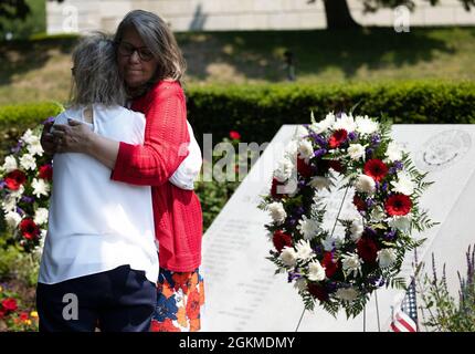 I membri della famiglia Gold Star si abbracciano dopo aver deposto le corone al memoriale del Giardino degli Eroi durante una cerimonia di posa della corona il 26 maggio 2021 presso la Rhode Island state House, Providence, R.I. La cerimonia di posa della corona è stata tenuta per altri per rendere omaggio ai membri del servizio di Rhode Island che hanno fatto il sacrificio finale dal 11 settembre 2001. Foto Stock