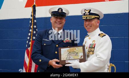 Michael Roschel, capo maestro Shawn Burns, regala una targa a nome del Mess del capo di Portsmouth di base. Il Capitano John Dewey ha sollevato il Capitano Michael Roschel come comandante della base della Guardia Costiera Portsmouth in una cerimonia di cambio di comando a base Portsmouth mercoledì 26 maggio 2021, che è stato presieduto dal direttore della logistica operativa posteriore ADM. Melvin Bouboulis. Foto Stock