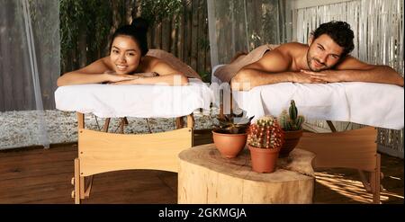 Coppia felice sdraiata sui tavoli da massaggio mentre weekend romantico al centro benessere spa. massaggio e riposo per coppie sposate Foto Stock