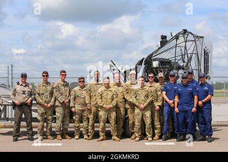 I membri con la Guardia Costiera Aids al Team di navigazione Sabine, l'Esercito degli Stati Uniti e la Guardia Nazionale dell'Esercito degli Stati Uniti posano per una foto vicino Beaumont, Texas, 27 maggio 2021. Le squadre hanno lavorato insieme per rimuovere una torre che era diventata un pericolo di navigazione dopo essere stata abbattuta durante l'uragano Laura. Foto Stock