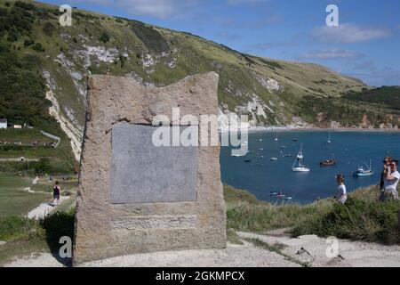 Una pietra che segna la Costa Dorset come parte del Patrimonio Mondiale a Lulworth Cove nel Dorset nel Regno Unito Foto Stock