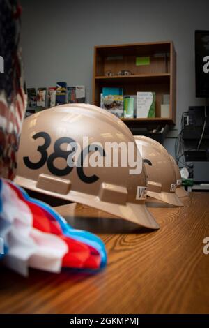 PORT ORCHARD, Washington (28 maggio 2021) – i cappelli duri riposano su un tavolo al South Kitsap High School (SKHS) maggio 28. Il personale di leadership della Trident Refem Facility Bangor (TRFB) ha lavorato con i consulenti di SKHS per identificare tre anziani altamente motivati della scuola superiore che hanno un interesse nel lavoro commerciale e li ha intervistati per un potenziale impiego alla TRFB. Foto Stock