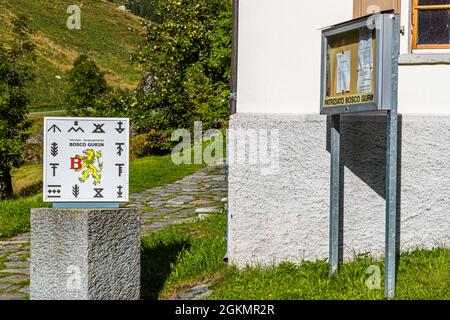 Presso la sala parrocchiale di Bosco Gurin si trova una targa con i 12 simboli delle famiglie locali, Circolo della Rovana, Svizzera Foto Stock