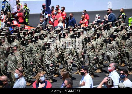 I membri delle forze armate salutano durante le cerimonie di apertura dell'Indy 500 all'autodromo di Indianapolis, il 30 maggio 2021. Durante le due settimane che hanno portato alla Indianapolis 500, si svolgono diversi eventi per onorare i membri del servizio militare e le loro famiglie. Foto Stock