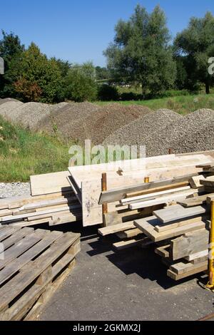 molti assi di legno su un luogo di costruzione ed altri materiali per costruire Foto Stock