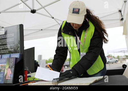 Karen Robertson, un volontario, cerca il nome di un membro di servizio per trovare la posizione della loro incisione sul Muro che guarisce ospitato dal National Veterans Memorial Museum a Columbus, Ohio, 29 maggio 2021. Il muro include simboli che indicano se un membro del servizio è deceduto, presunto morto, mancante o imprigionato. Foto Stock