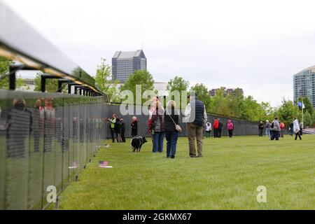 I visitatori pagano il loro omaggio agli oltre 58,000 uomini e donne che hanno servito e perso la vita o che rimangono mancanti durante la guerra del Vietnam durante la visita al Muro che guarisce ospitato dal National Veterans Memorial Museum a Columbus, Ohio, 29 maggio 2021. La replica itinerante del Vietnam Veterans Memorial a Washington, DC è stata esposta in quasi 700 comunità in tutta la nazione dal 1996. Foto Stock