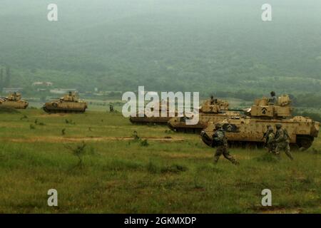 I soldati dell'esercito degli Stati Uniti dalla Charlie Company, secondo battaglione, quinto reggimento di cavalleria, avanzano mentre sono smontati accanto ai loro veicoli di combattimento di fanteria M2 Bradley durante Balkan Sentinel 21 alla gamma di addestramento di Novo Selo, Bulgaria, 31 maggio 2021. Balkan Sentinel 21 è un'esercitazione combinata di fuoco dal vivo a guida bulgara, condotta in collaborazione con Saber Guardian 21, che coinvolge forze armate e meccanizzate bulgare, georgiane e statunitensi. Sabre Guardian 21 è un esercizio collegato di DEFENDER-Europe 21. DEFENDER-Europe 21 è un'esercitazione su larga scala condotta dall'esercito degli Stati Uniti, progettata per migliorare la prontezza e l'interoperabilità Foto Stock