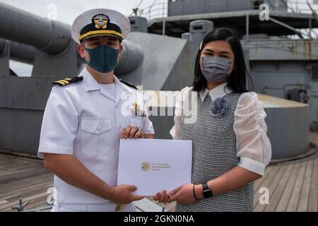 210602-N-HH215-1039 YOKOSUKA, Giappone (2 giugno 2021) – Mary Joy David-Tactay riceve un certificato di naturalizzazione dal Lt. Andrew Decker, responsabile del dipartimento di assistenza legale assegnato all'Ufficio legale regionale del Pacifico occidentale, durante una cerimonia di naturalizzazione a bordo della nave commemorativa giapponese Mikasa. Durante la cerimonia, sette marinai e civili originari della Costa d’Avorio, delle Filippine, della Sierra Leone e di Taiwan sono diventati cittadini naturalizzati degli Stati Uniti d’America. Foto Stock