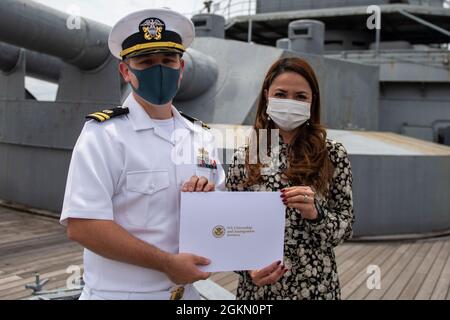 210602-N-HH215-1042 YOKOSUKA, Giappone (2 giugno 2021) – Elaine Joy DeCastro riceve un certificato di naturalizzazione dal Lt. Andrew Decker, responsabile del dipartimento di assistenza legale assegnato all'Ufficio legale regionale del Pacifico occidentale, durante una cerimonia di naturalizzazione a bordo della nave commemorativa giapponese Mikasa. Durante la cerimonia, sette marinai e civili originari della Costa d’Avorio, delle Filippine, della Sierra Leone e di Taiwan sono diventati cittadini naturalizzati degli Stati Uniti d’America. Foto Stock