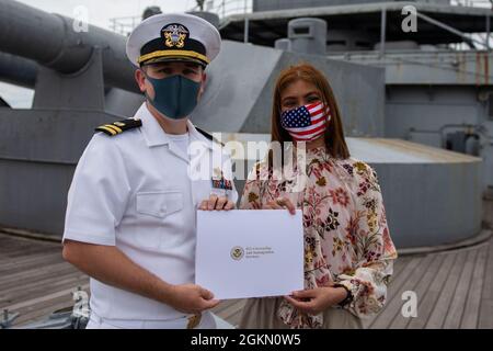 210602-N-HH215-1045 YOKOSUKA, Giappone (2 giugno 2021) – Genalyn Hickerson riceve un certificato di naturalizzazione dal Lt. Andrew Decker, responsabile del dipartimento di assistenza legale assegnato all'Ufficio legale regionale del Pacifico occidentale, durante una cerimonia di naturalizzazione a bordo della nave commemorativa giapponese Mikasa. Durante la cerimonia, sette marinai e civili originari della Costa d’Avorio, delle Filippine, della Sierra Leone e di Taiwan sono diventati cittadini naturalizzati degli Stati Uniti d’America. Foto Stock