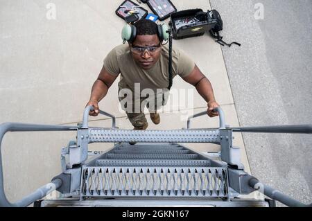 Senior Airman Elijah Turner, 911th Aircraft Maintenance Squadron Crew Chief, sale su uno stand di manutenzione dopo aver cambiato una luce su un C-17 Globemaster III alla stazione di riserva aerea dell'aeroporto internazionale di Pittsburgh, Pennsylvania, 2 giugno 2021. Manutenzione gli Airmen utilizzano cavalletti specializzati per eseguire in modo sicuro ed efficace la manutenzione su parti dell'aeromobile a cui non possono accedere quando sono in piedi a terra. Foto Stock