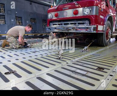 I membri della 30a Aerial Port Squadron, Niagara Falls Air Reserve Station, N.Y. e 433rd Airlift Wing dalla Joint base di San Antonio-Lackland, Texas, assicurano un camion fuoco donato su una C-5 Galaxy presso l'aeroporto internazionale di Niagara Falls il 2 giugno 2021. Il camion dei pompieri e le forniture umanitarie supplementari sono stati donati da Global Medic da Toronto, Canada e coordinati attraverso il programma di assistenza umanitaria Denton destinato al Nicaragua. Foto Stock