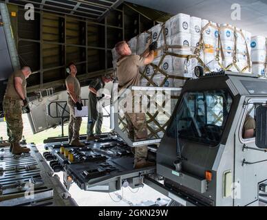 I membri della 30a Aerial Port Squadron, Niagara Falls Air Reserve Station, N.Y. e 433rd Airlift Wing dalla Joint base di San Antonio-Lackland, Texas, caricano le forniture umanitarie donate su una C-5 Galaxy all'Aeroporto Internazionale di Niagara Falls il 2 giugno 2021. Un camion dei pompieri e forniture umanitarie supplementari sono stati donati da Global Medic da Toronto, Canada e destinati al Nicaragua. Foto Stock