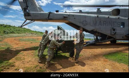 Marines USA e marinai con Marine Heavy Helicopter Squadron (HMH) 462, 9° supporto tecnico Battalion e Navy Mobile Construction Battalion 4, scaricare l'attrezzatura da un elicottero CH-53E Super Stallion come parte di Poseidon Watchtower, al largo della costa di Okinawa, Giappone, 3 giugno 2021. Poseidon Watchtower è un'operazione congiunta tra i Marines degli Stati Uniti e la Marina degli Stati Uniti per migliorare le capacità di operazioni di base avanzate di spedizione nell'area di responsabilità Indo-Pacific. Foto Stock