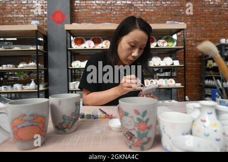 Xuanhua, Xuanhua, Cina. 15 settembre 2021. Il 15 settembre 2021, il pittore del Museo Nazionale della Ceramica della Giada nel distretto di Xuanhua, nella città di Zhangjiakou, nella provincia di Hebei, ha eseguito una dimostrazione di pittura underglaze. Negli ultimi anni, il distretto di Xuanhua, la città di Zhangjiakou, la provincia di Hebei ha esplorato completamente la storia e la cultura industriale. Nell'implementazione del trasferimento e della trasformazione della vecchia zona industriale, Xuanhua Guoyu Ceramics Co., Ltd. Ha rilocato le vecchie officine e linee di produzione che hanno una storia di più di 60 anni in un museo di ceramica. Attraverso immagini e phy Foto Stock