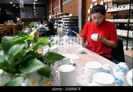 Xuanhua, Xuanhua, Cina. 15 settembre 2021. Il 15 settembre 2021, il pittore del Museo Nazionale della Ceramica della Giada nel distretto di Xuanhua, nella città di Zhangjiakou, nella provincia di Hebei, ha eseguito una dimostrazione di pittura underglaze. Negli ultimi anni, il distretto di Xuanhua, la città di Zhangjiakou, la provincia di Hebei ha esplorato completamente la storia e la cultura industriale. Nell'implementazione del trasferimento e della trasformazione della vecchia zona industriale, Xuanhua Guoyu Ceramics Co., Ltd. Ha rilocato le vecchie officine e linee di produzione che hanno una storia di più di 60 anni in un museo di ceramica. Attraverso immagini e phy Foto Stock