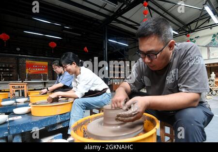 Xuanhua, Xuanhua, Cina. 15 settembre 2021. Il 15 settembre 2021, i visitatori sperimentano la produzione di ceramiche al Museo Nazionale della Giada nel quartiere di Xuanhua, nella città di Zhangjiakou, nella provincia di Hebei. Negli ultimi anni, il distretto di Xuanhua, la città di Zhangjiakou, la provincia di Hebei ha esplorato completamente la storia e la cultura industriale. Nell'implementazione del trasferimento e della trasformazione della vecchia zona industriale, Xuanhua Guoyu Ceramics Co., Ltd. Ha rilocato le vecchie officine e linee di produzione che hanno una storia di più di 60 anni in un museo di ceramica. Attraverso immagini e oggetti fisici, l'istore Foto Stock