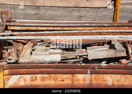 stack di accessori arrugginiti in cantiere immagazzinati in un carro di ferro Foto Stock