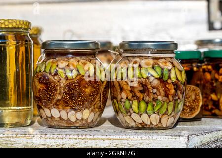 Miele in un vaso di vetro con noci e frutta per la vendita per il turista in Montenegro mercato alimentare, primo piano Foto Stock